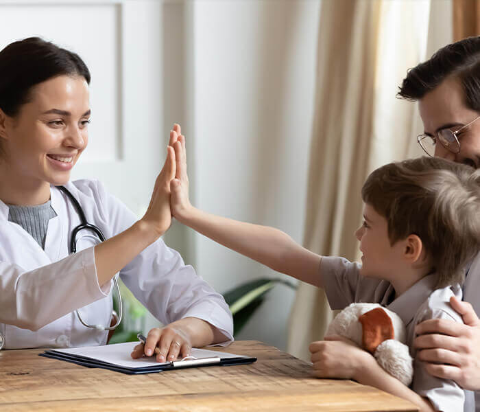 Request an Appointment female pediatrician giving high five to young patient